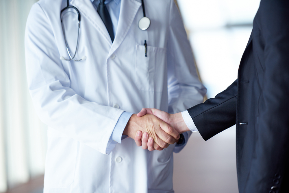 doctor handshake with a patient at doctors bright modern office in hospital-2