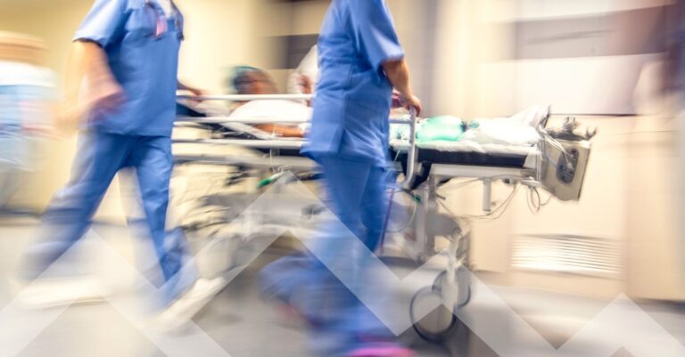 Hospital staff rushing a patient on a stretcher in an emergency department, illustrating rising emergency medicine physician demand.