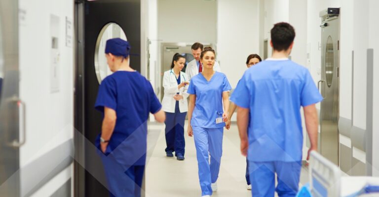Hospital holiday staffing during peak winter demand, with clinicians providing coverage in a hospital hallway